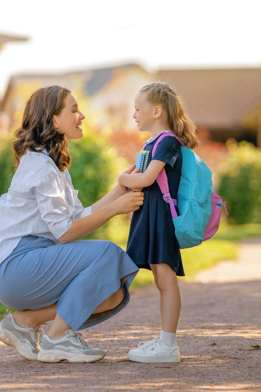 Mom and daughter stnding in front of School