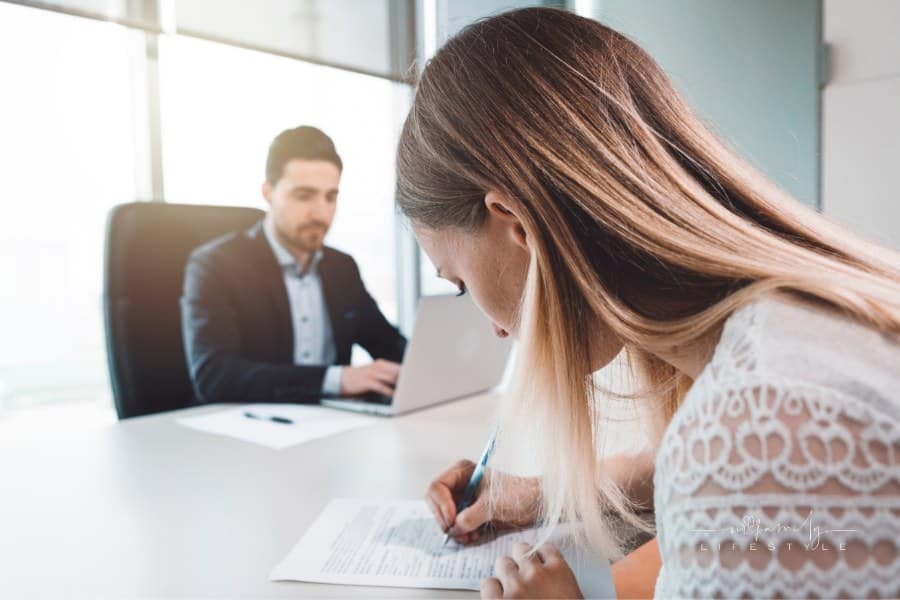 Woman Signing divorce papers in front of lawyer