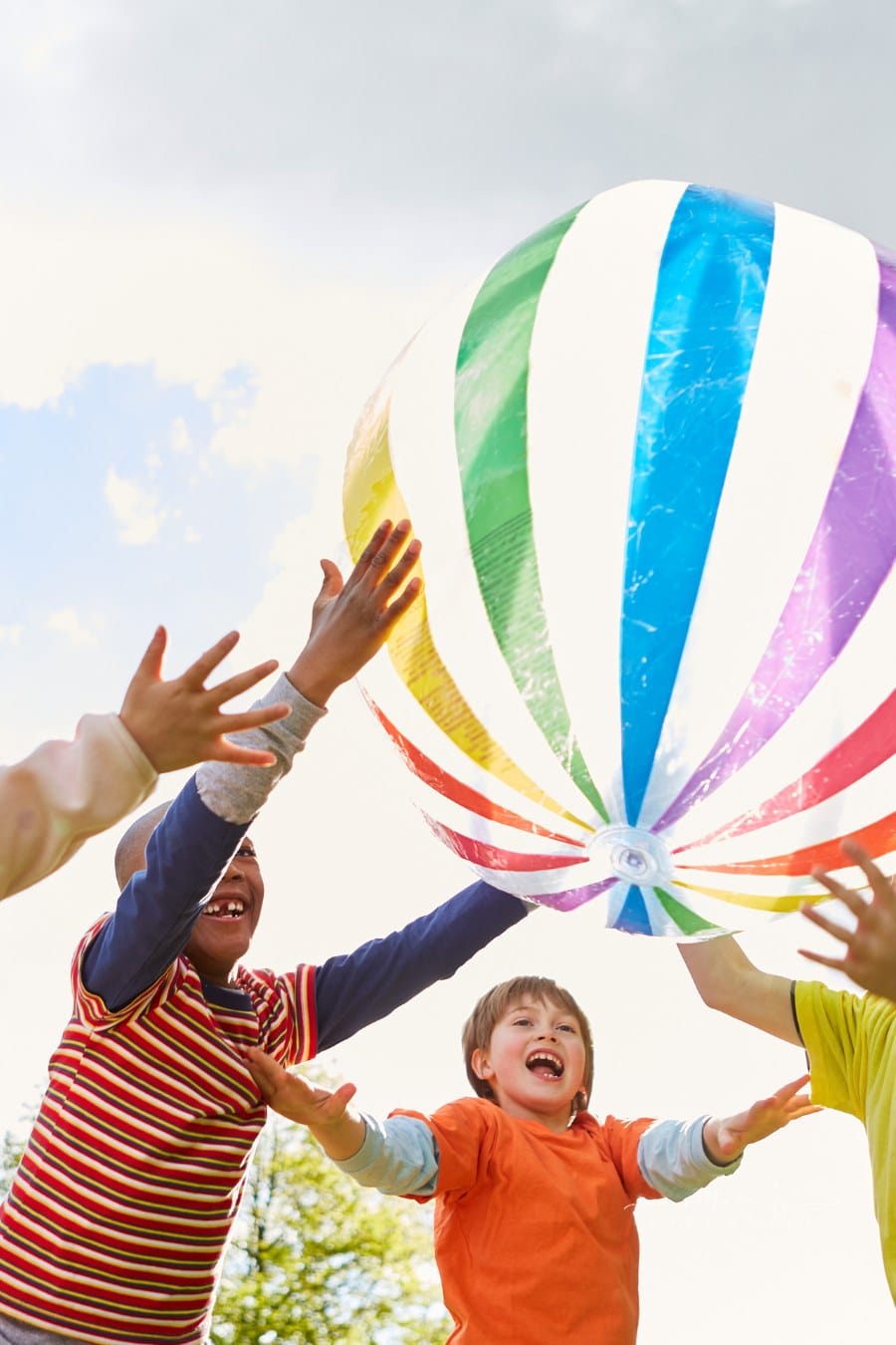 Preschool Children Playing With Large Blown Up Ball in the Park