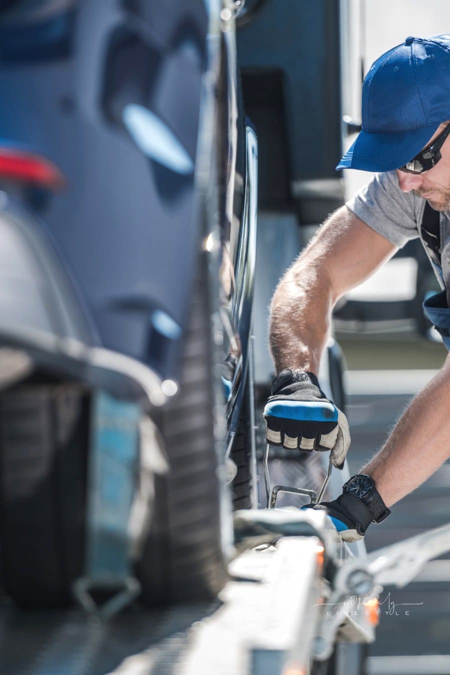 Tow Truck Driver Securing Vehicle on the Platform