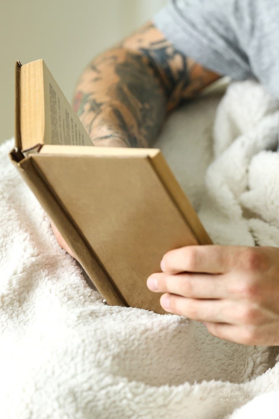 man with brown book reading
