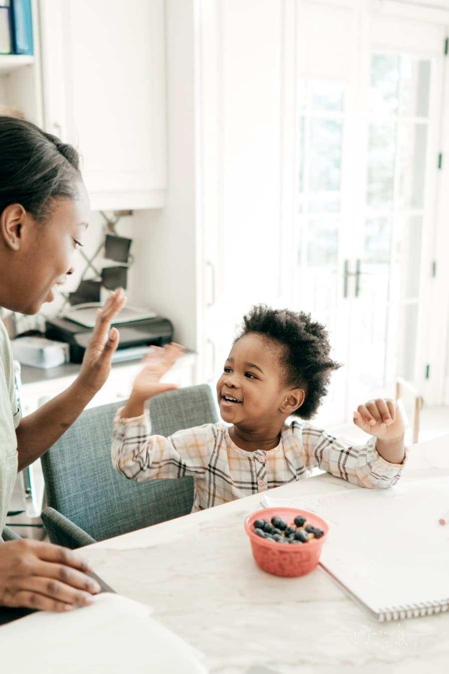 mom giving toddler daughter a high five