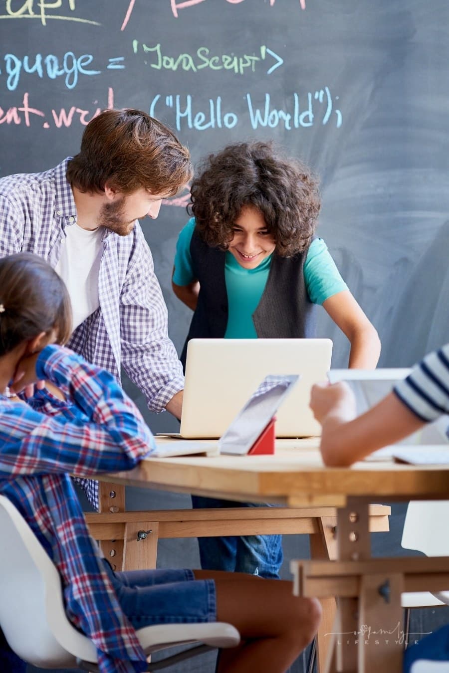 teacher showing teens lesson on a laptop