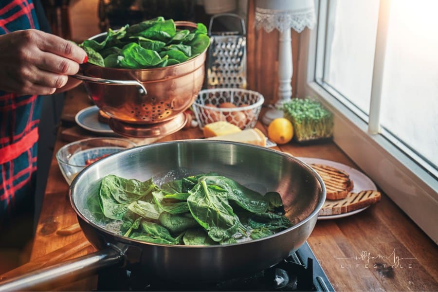 preparing greens in skillet for poke salad