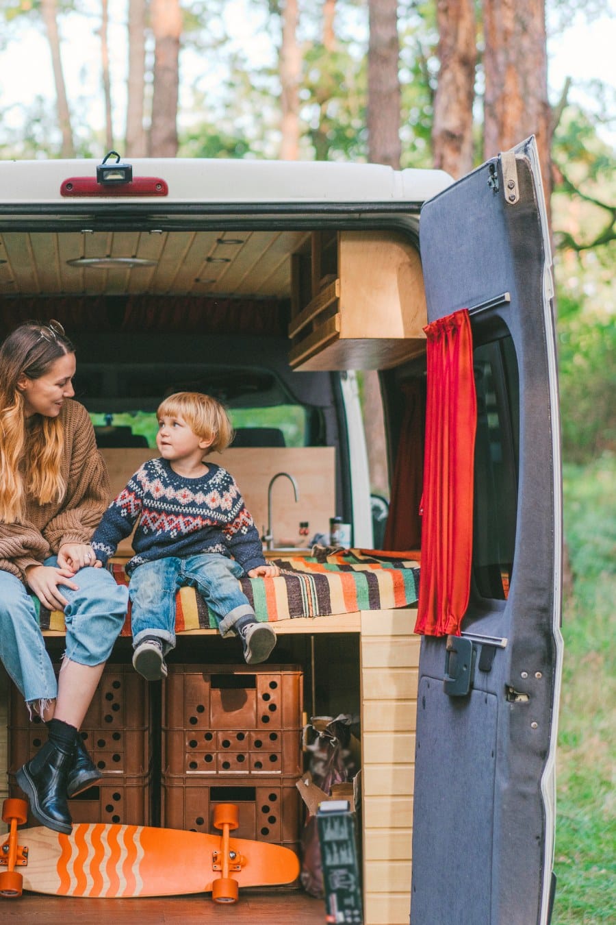 Woman with son sitting in camper van