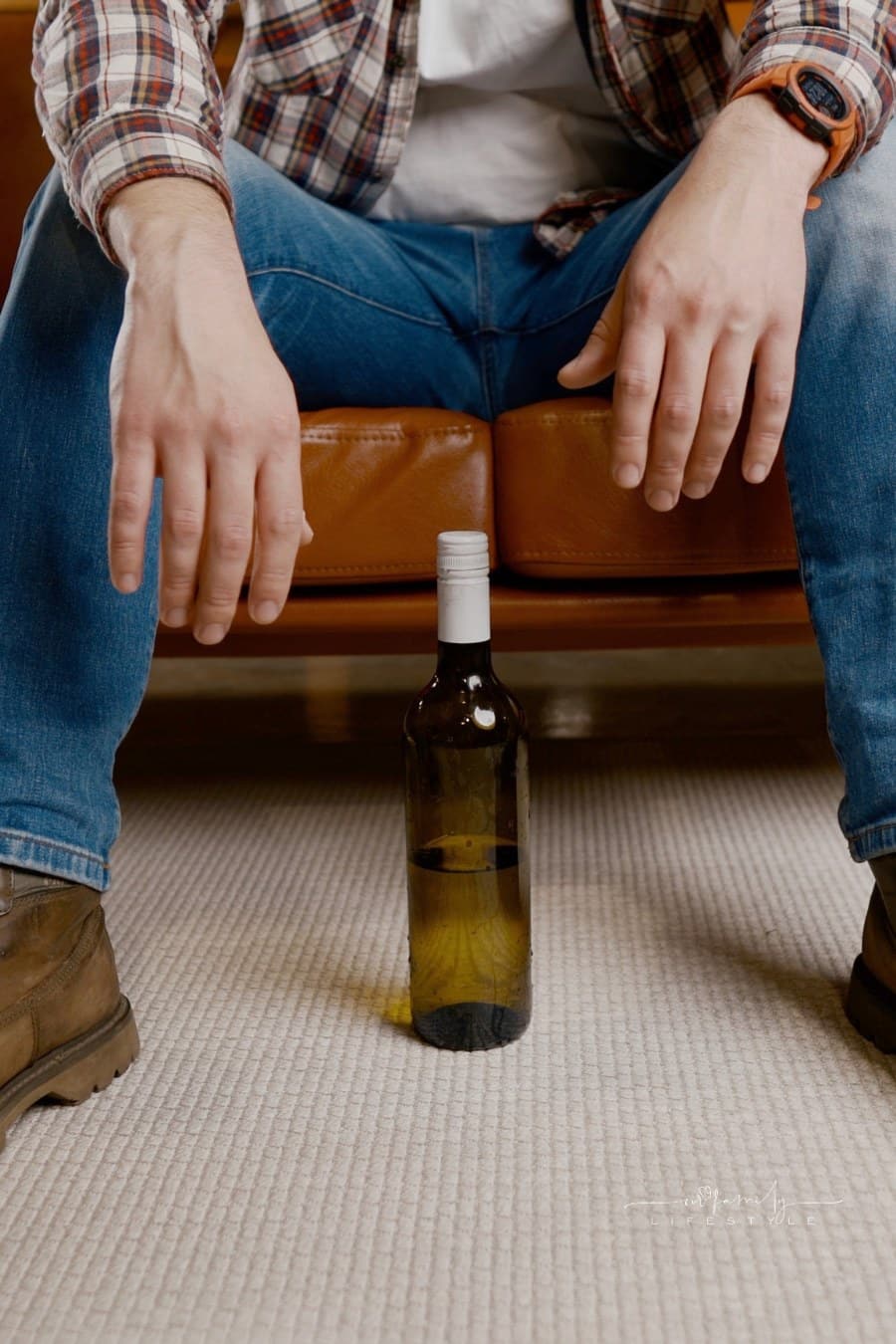 Alcohol addiction at young age. Caucasian male cannot stop drinking alcohol, drunken lonely male drinks wine from bottle. Loneliness, depression and alcoholism during Christmas and New Year holidays