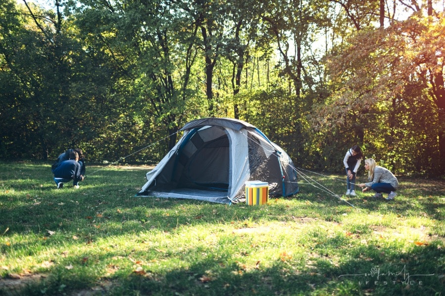 family putting a camping tent up together