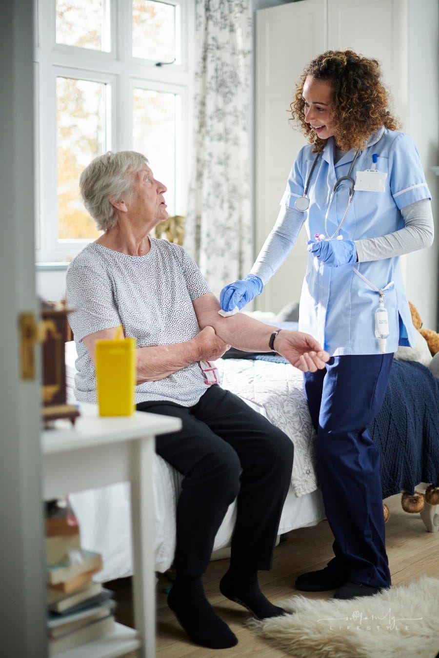home caregiver giving senior woman her medicine