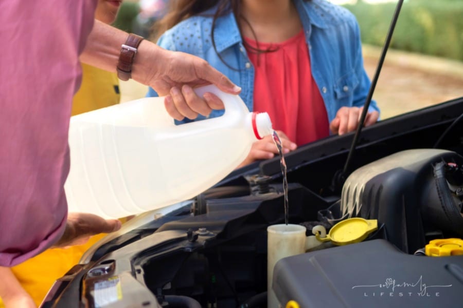 family adding fluids to maintain car