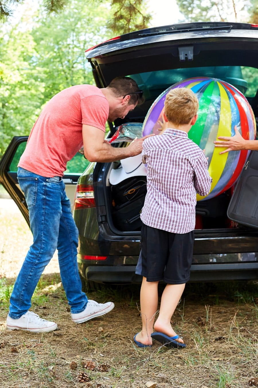family loading a car together for summer vacation