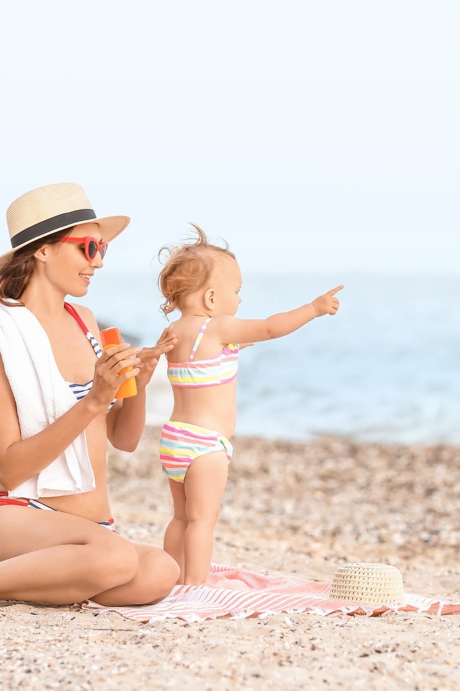 Mother and Her Little Daughter with Sunscreen Cream