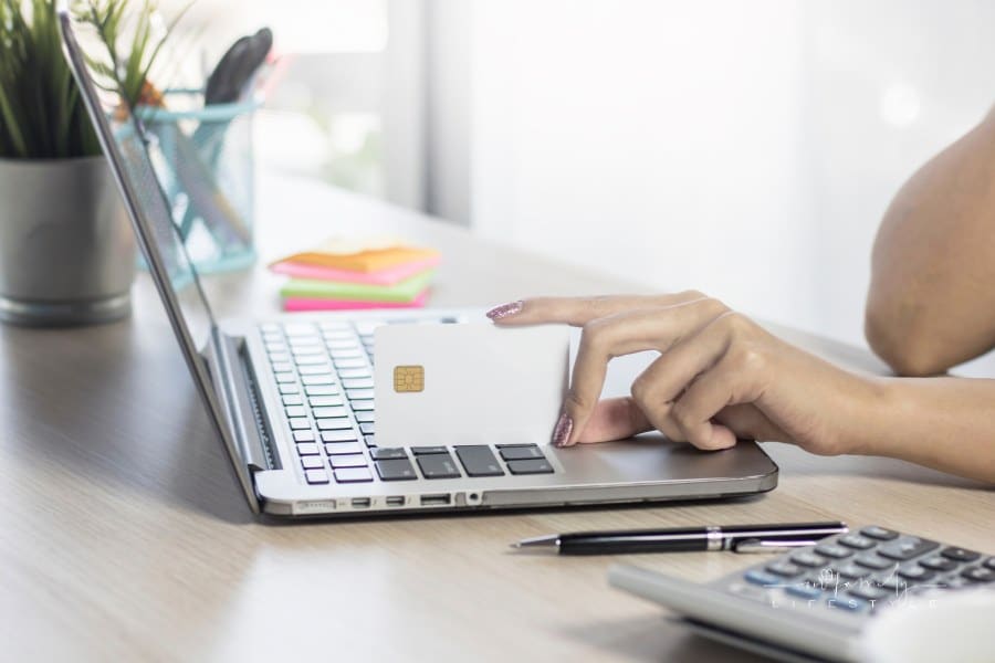 Woman shopping online holding credit card
