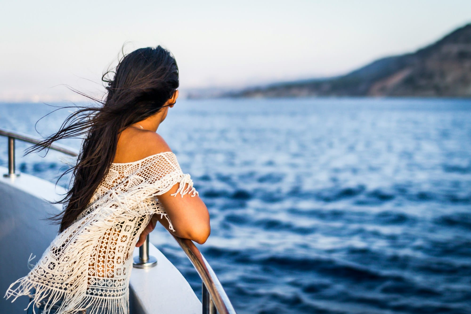 woman looking across ocean aboard a cruise ship