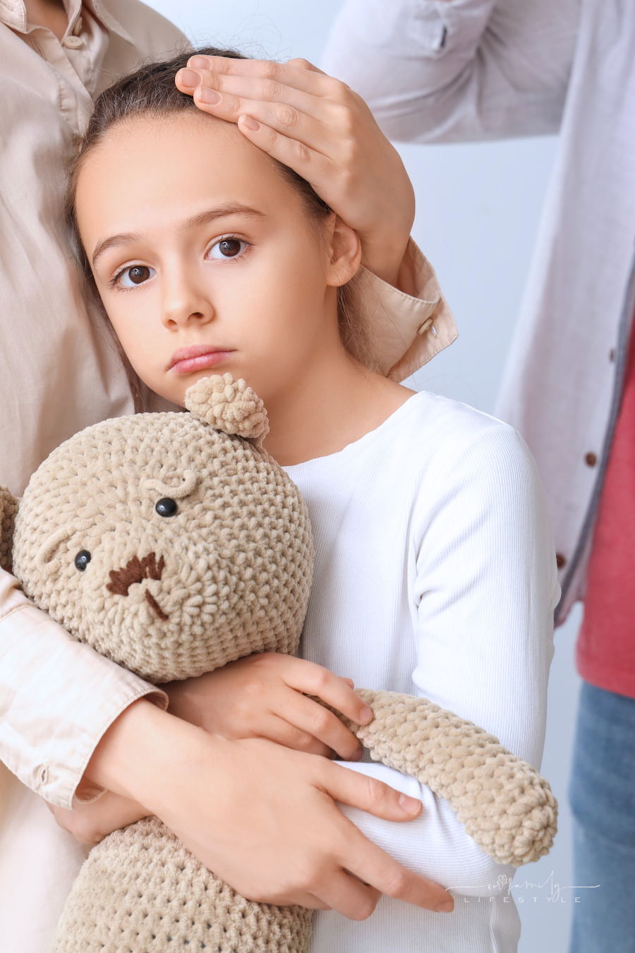 Sad Little Girl Hugging Her Mother before Leaving on Light Background. Divorce Concept