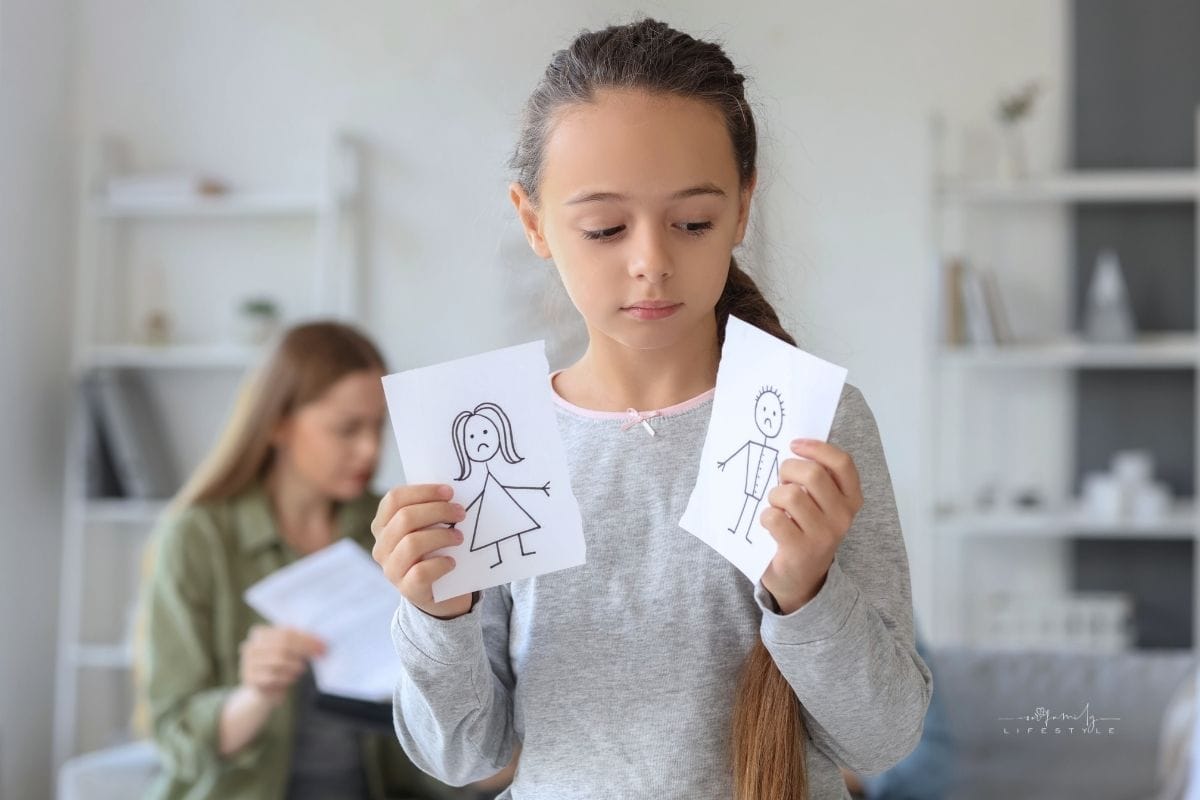 Sad Little Girl with Torn Drawing of  and Her Parents on Beige Background. Divorce Concept