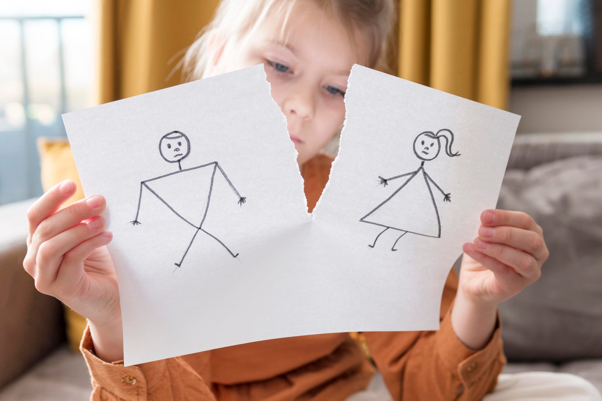 Medium shot girl holding broken drawing of stick figure couple