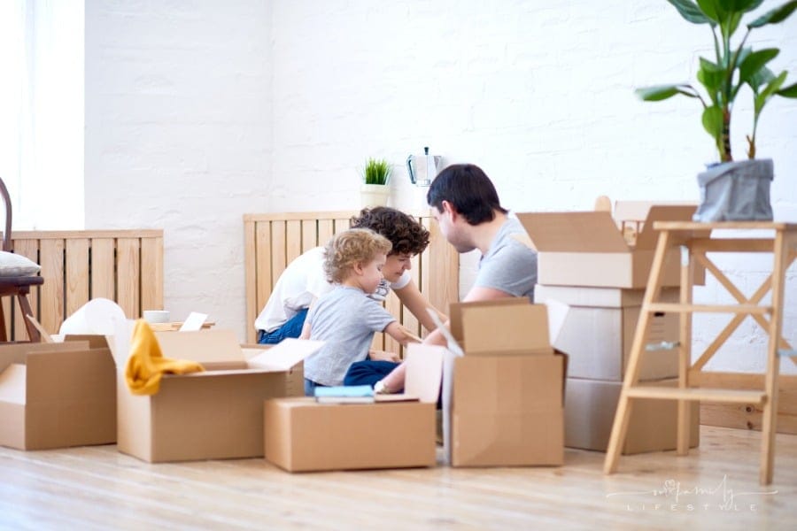 mother, father, and son unpacking boxes in new apartment