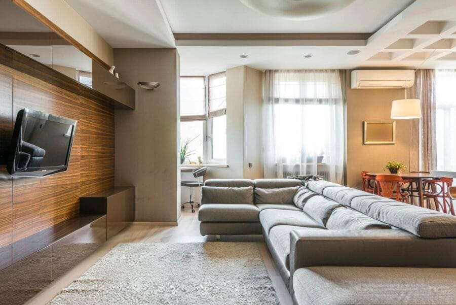 A cozy and modern living room with a large sofa and natural lighting.