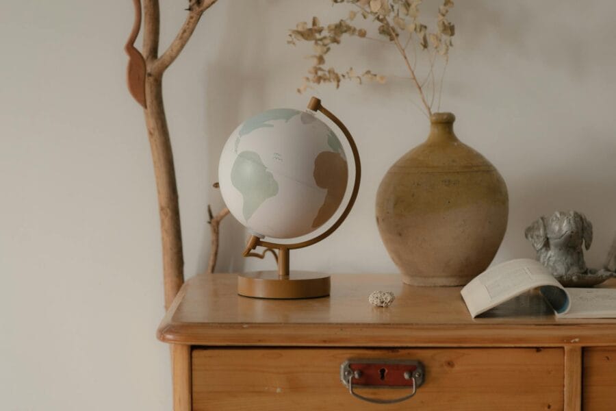 A serene composition featuring a globe, vase, and decor on a wooden table, perfect for home inspiration.