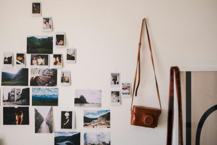 Aesthetic wall collage of vintage photos with a leather camera bag, adding a nostalgic vibe.