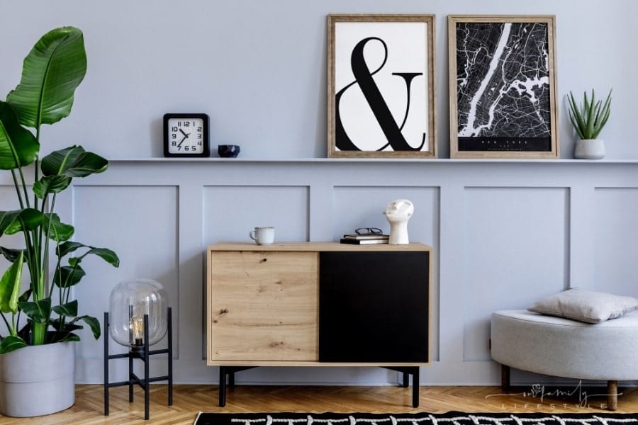 board and batten wall with picture ledge holding various wall art and home décor