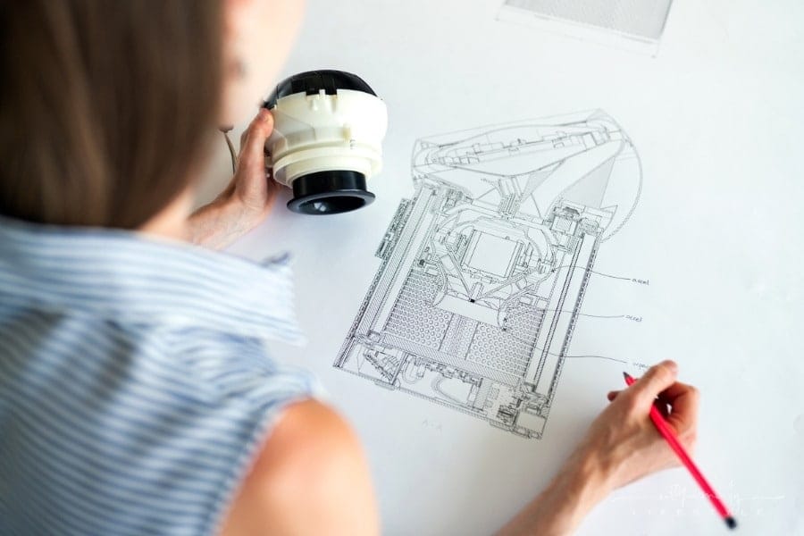 female engineer drawing technical blueprint