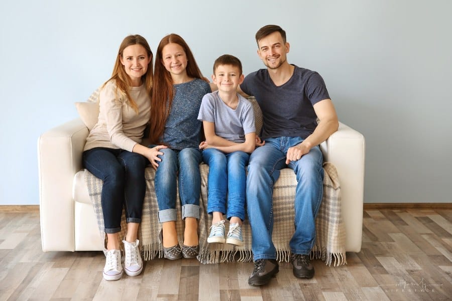 mom and dad sitting on couch with boy and girl children