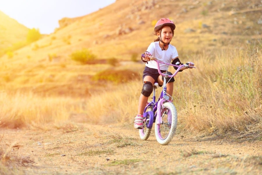 Happy Kid Having Fun in Autumn Park with a Bicycle with full bike gear on