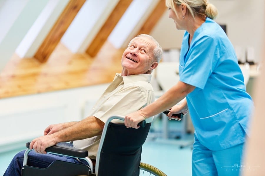 nurse pushing senior man in wheelchair