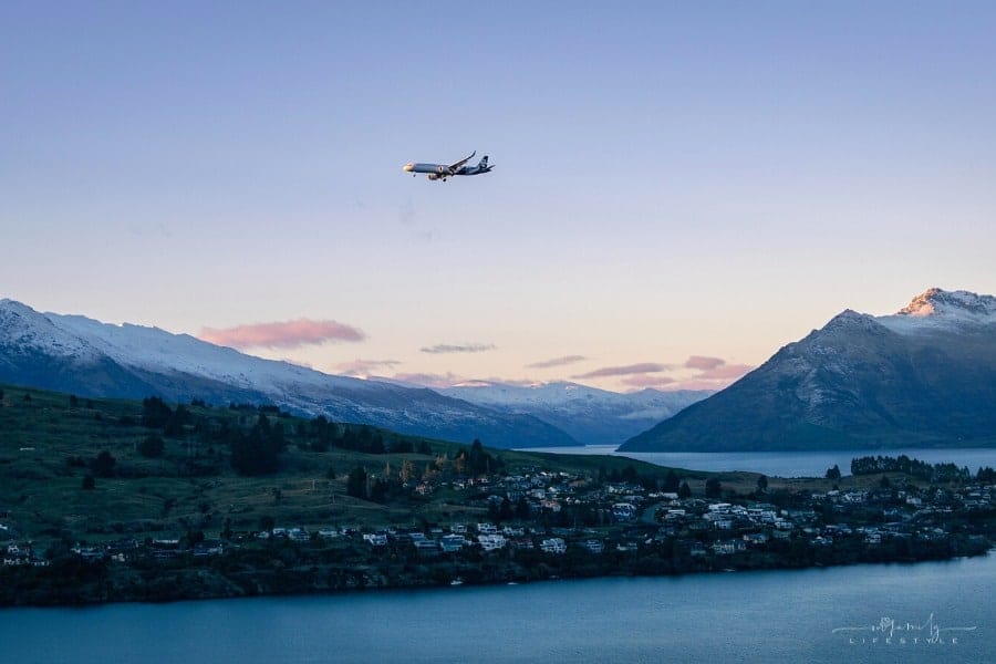 Air NZ plane flying over Lake Wakatipu in Queenstown, South Island, during sunset