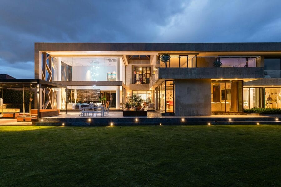 Explore a contemporary villa with a stunning facade, illuminated at dusk, highlighting its modern architecture.