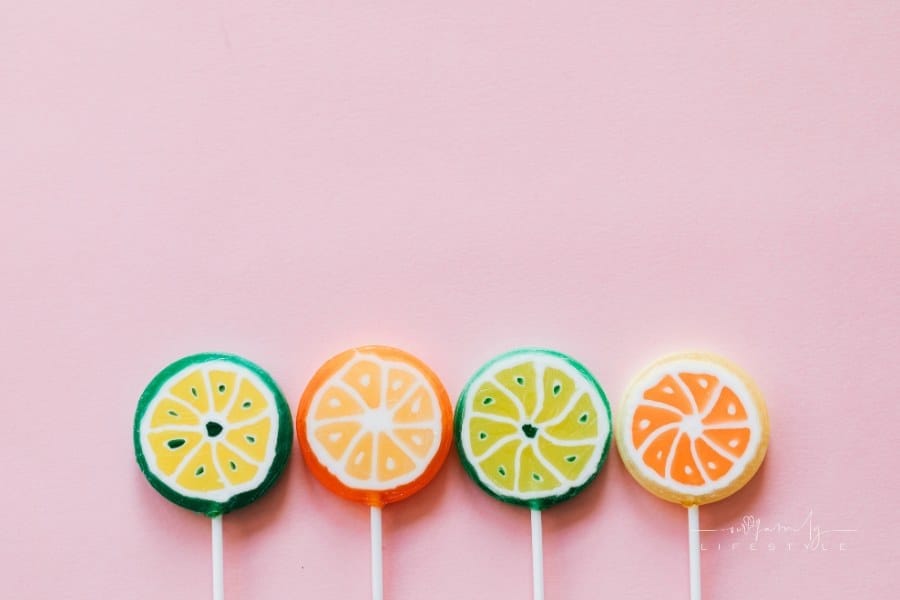 Assorted colorful lollipops on pink background