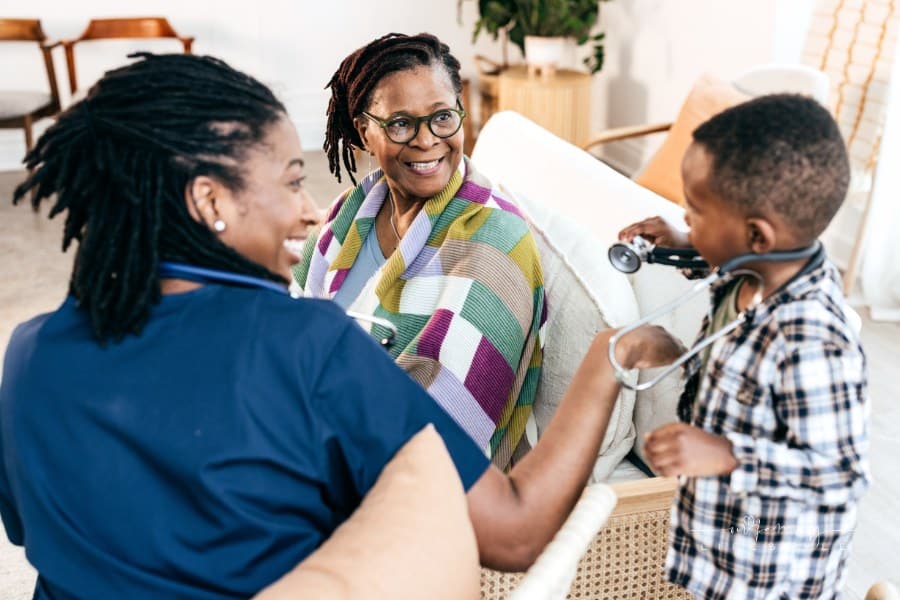 nurse helping grandson use stethoscope on his elderly grandmother at an assisted living community