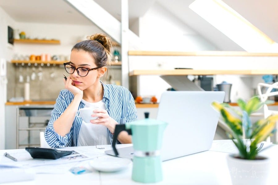 woman working on home budget with coffee in hand