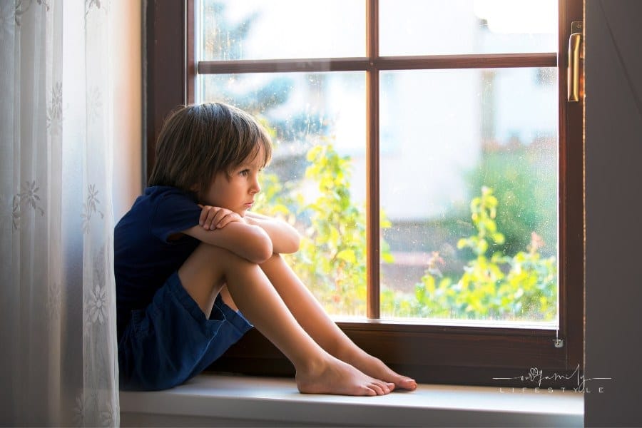 Sad child, boy, sitting on a window shield