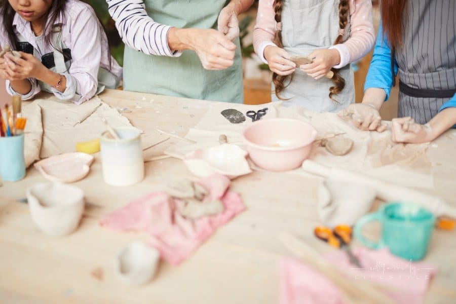 High angle closeup of children making handmade ceramics in pottery workshop