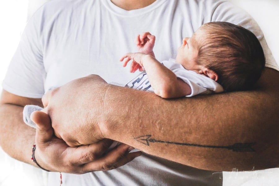 father holding newborn baby in his arms