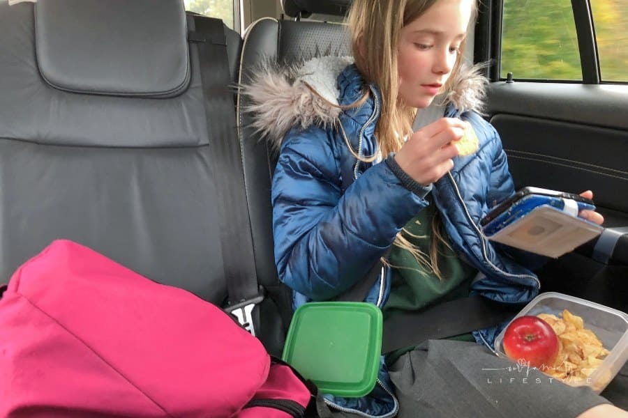 Girl eating after school snack in the car