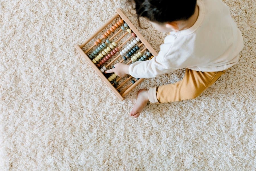 Top View of a Child Playing with an Educational Toy on carpet