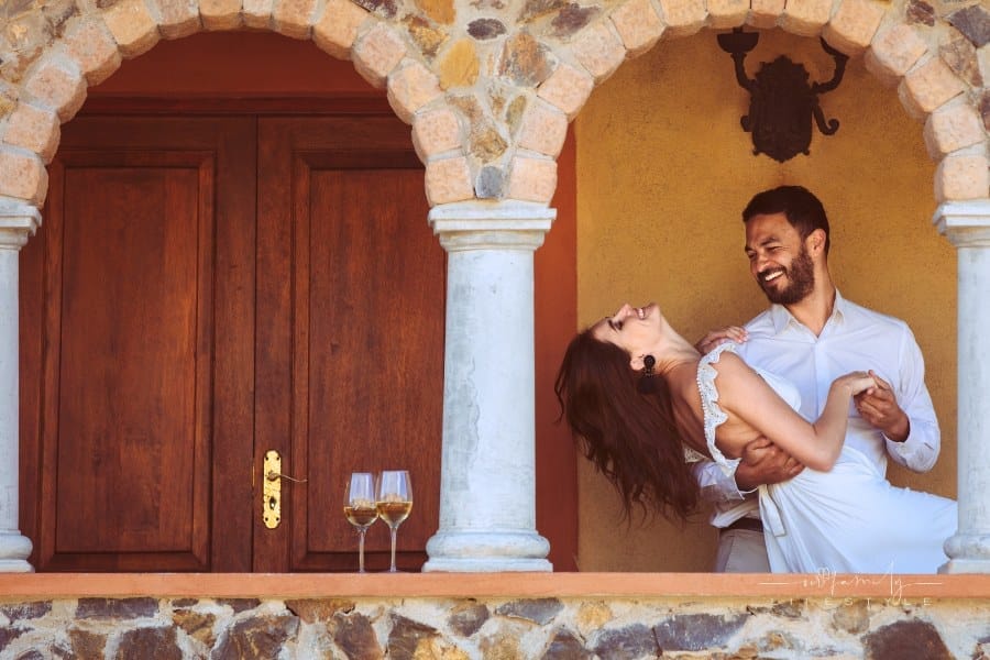 Happy couple dancing in the balcony of a building. Smiling man and woman on a date dancing together.