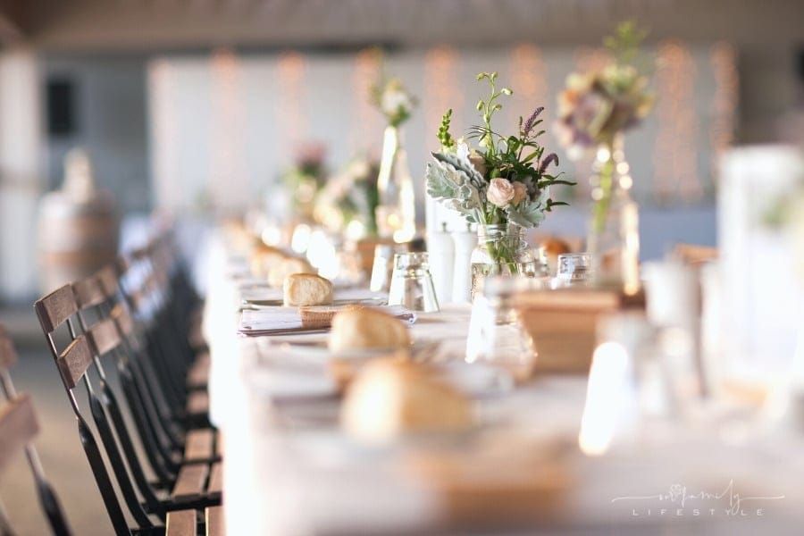 flowers, plates and bread on beautifully decorated wedding table