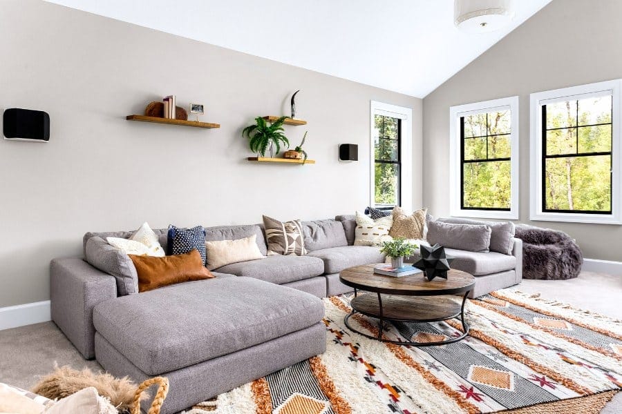 Beautiful living room interior with colorful area rug, large couch, and abundant natural light