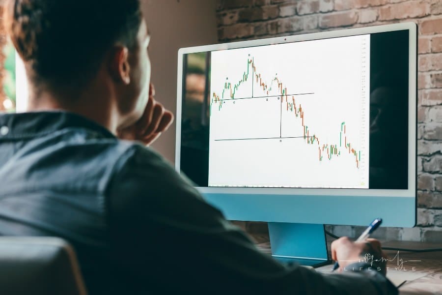 young day trader analyst looking at financial stock market charts rate dynamic, trading data indexes growth using mobile phon