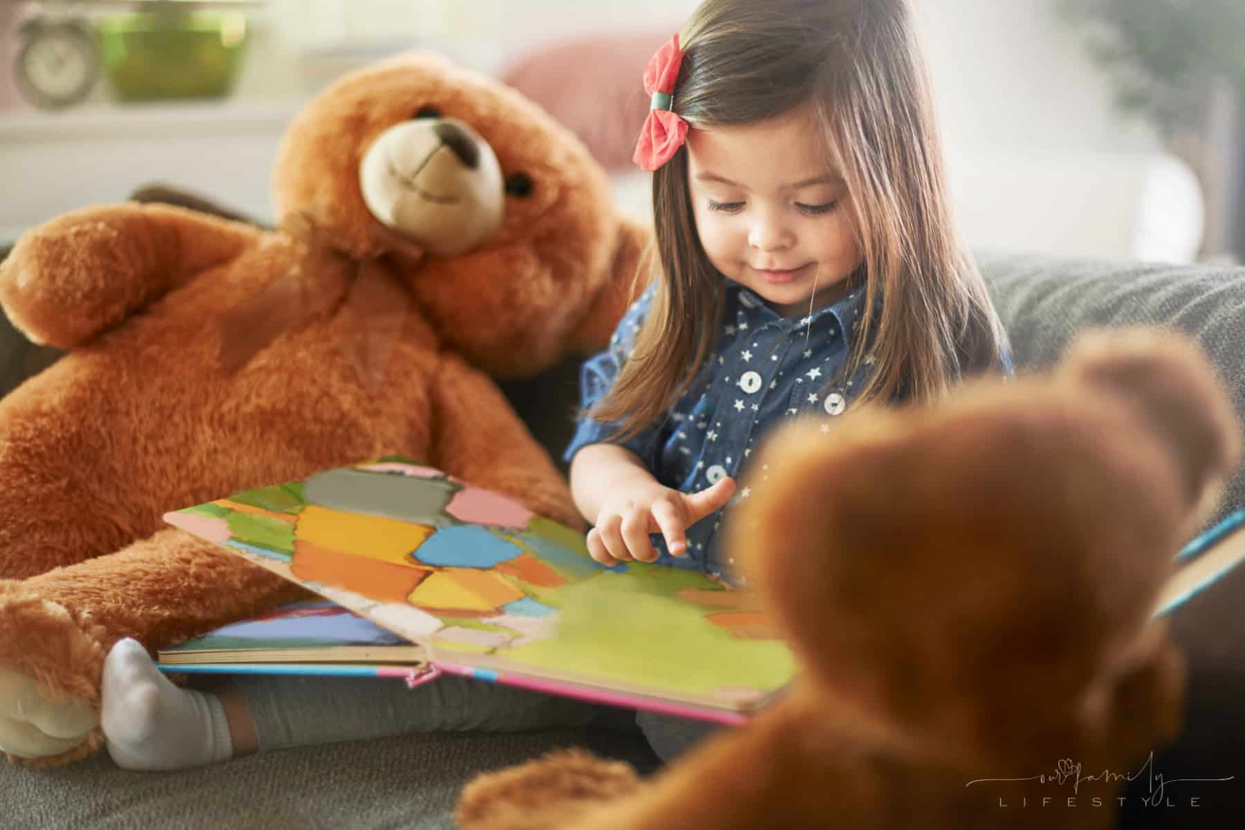 little-girl-reading-book-with-her-teddy-bears