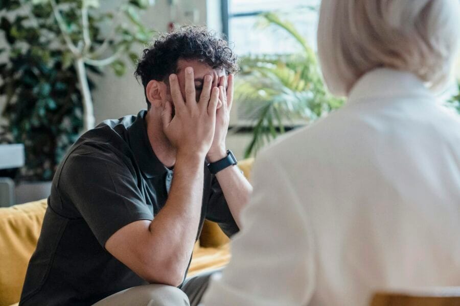 Man seeking support in therapy, expressing emotions during an indoor counseling session.
