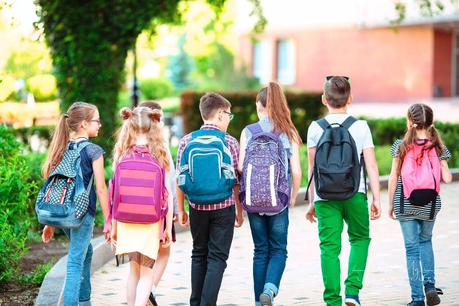 Group of kids going to school with backpacks on