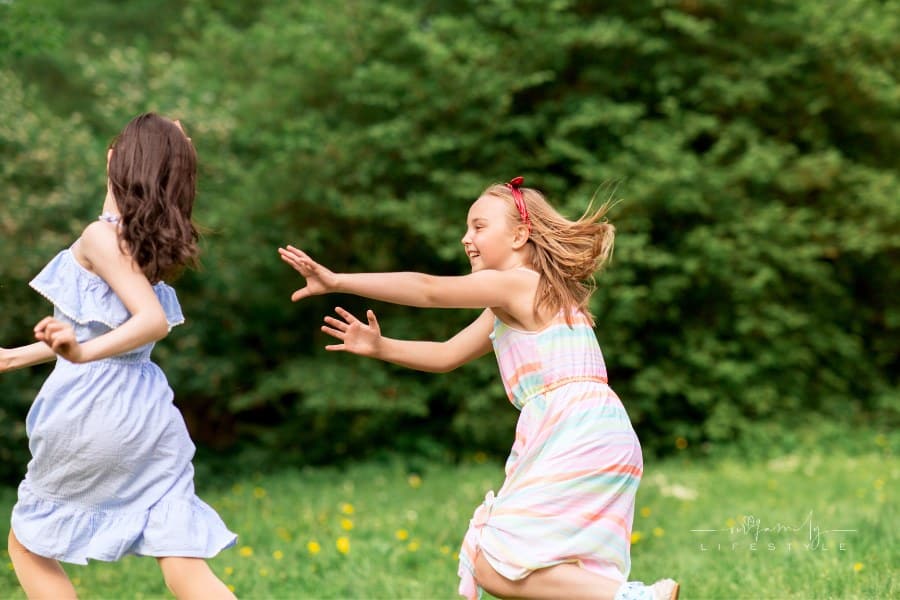 Happy Girls Playing Tag Game outdoors