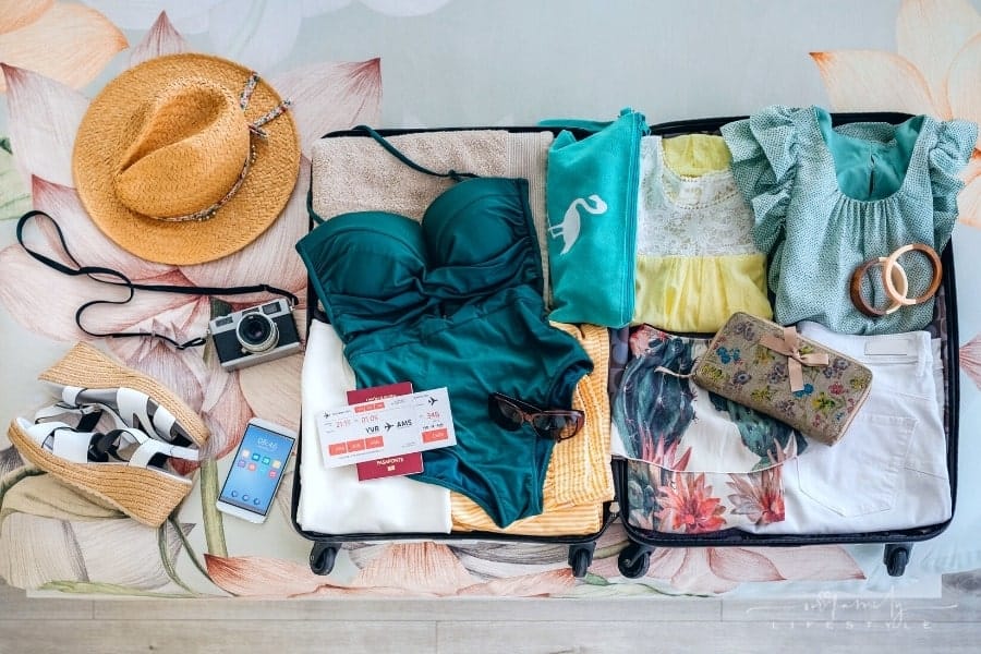 top view of open suitcase with bathing suit and beach clothes