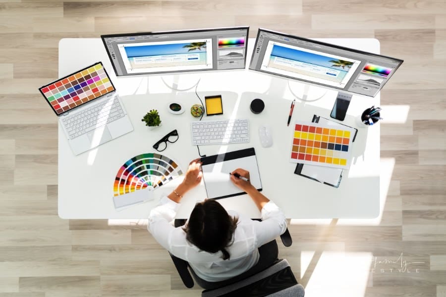 Graphic Designer Artist Working on multiple computer monitors