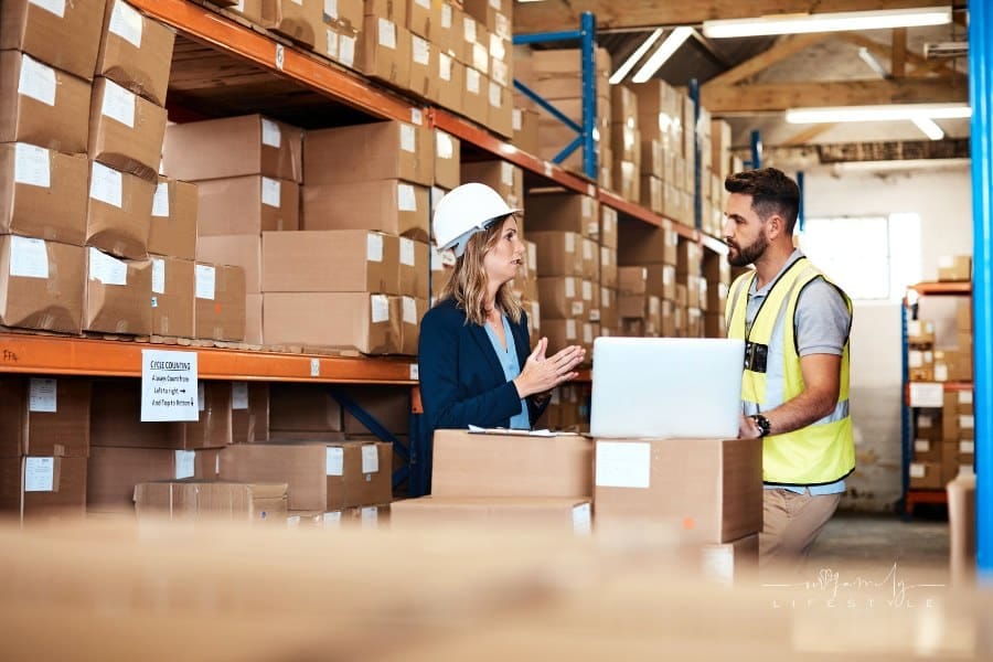 businesswoman working with warehouse worker on logistics with a laptop